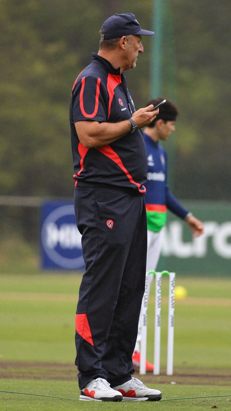 A coach working with a young player at a session